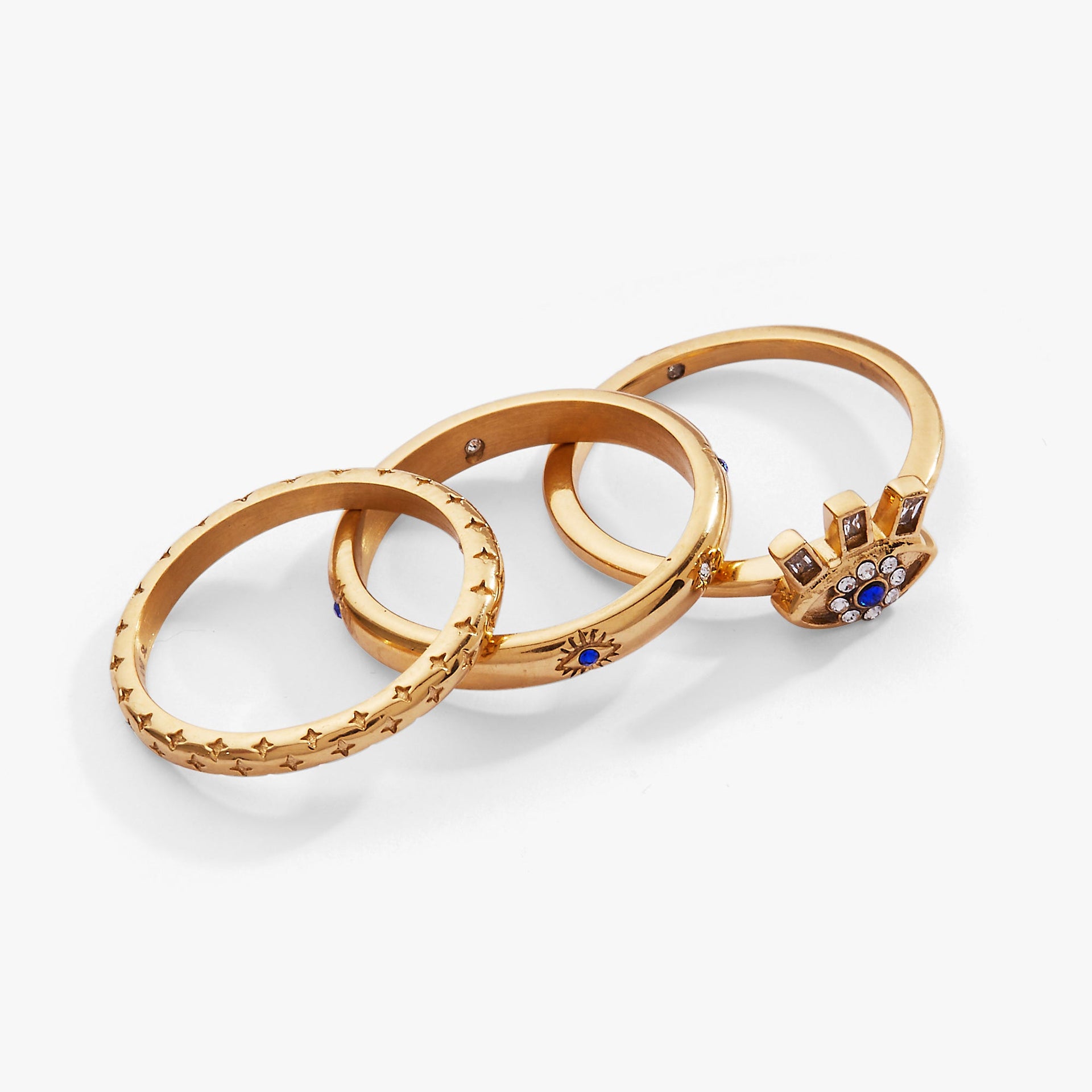 A set of three gold stackable rings with evil eye designs, blue accents, and clear crystals.