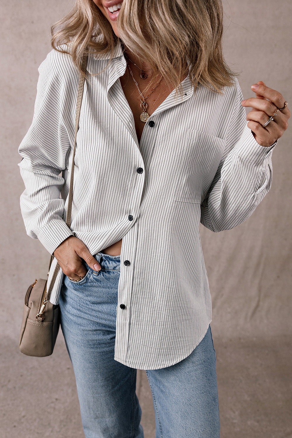 Women wearing a pinstripe button-down long shirt with tab sleeves in a relaxed fit