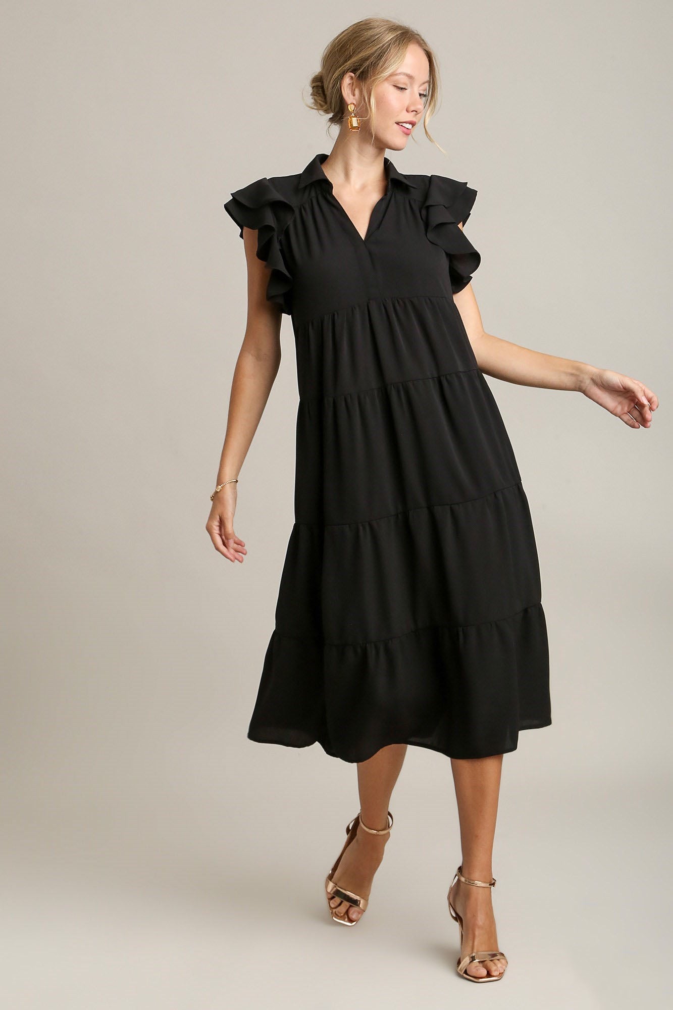 Elegant black tiered dress with ruffle cap sleeves and a minimalist silhouette