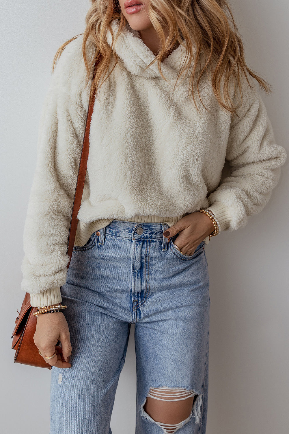 White plush hoodie with contrast ribbed hem and cuffs shown on a person and on a flat lay surface