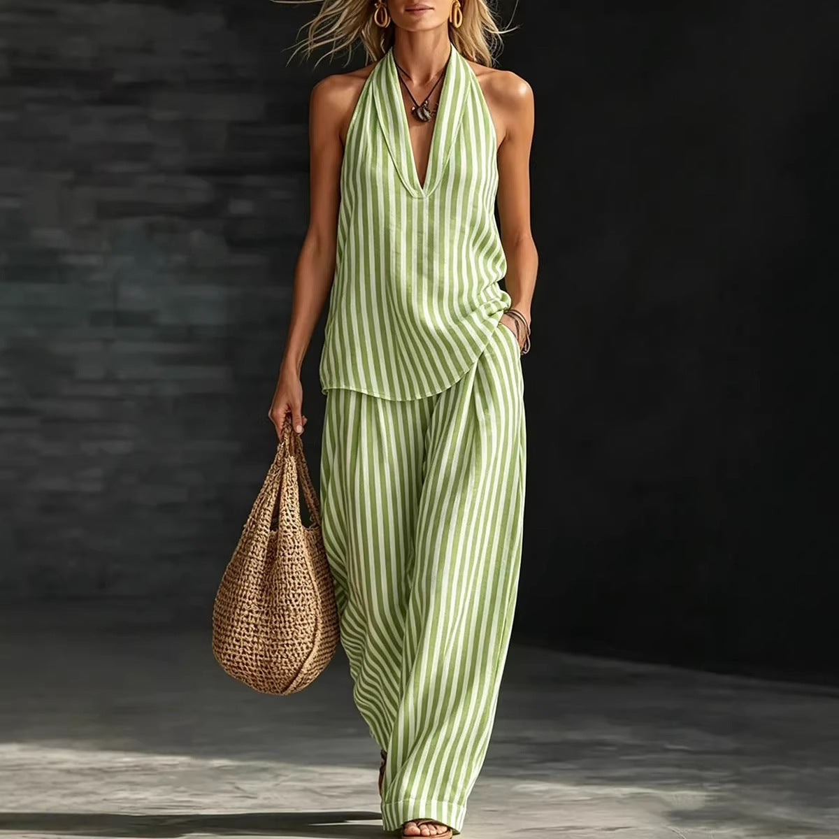 A woman wearing a green and white vertical striped sleeveless halter top and matching wide-leg pants set.