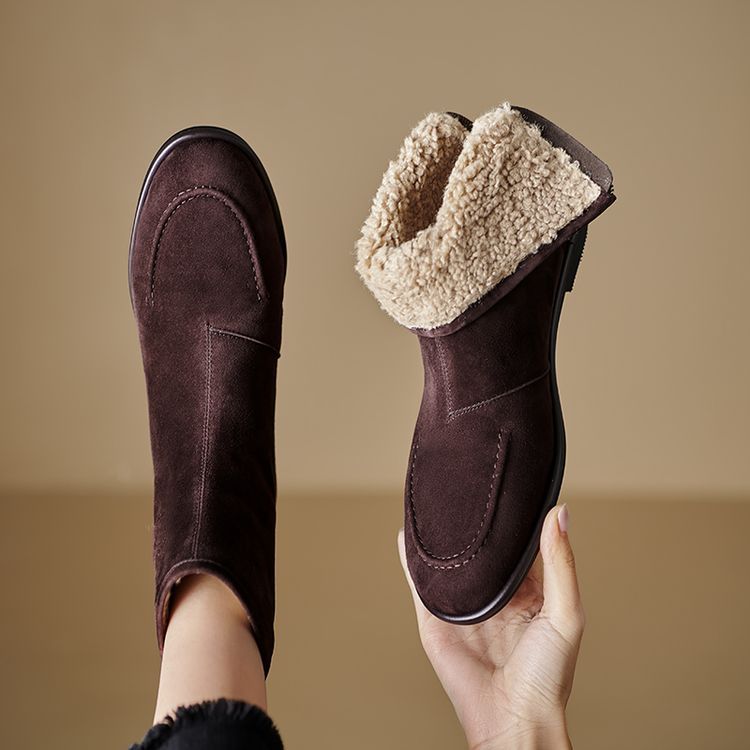 Women's dark brown and grey suede ankle boots featuring thick fleece lining and a round toe design being held up