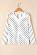 White long sleeve top with black chevron stripes and V-neckline displayed on a hanger
