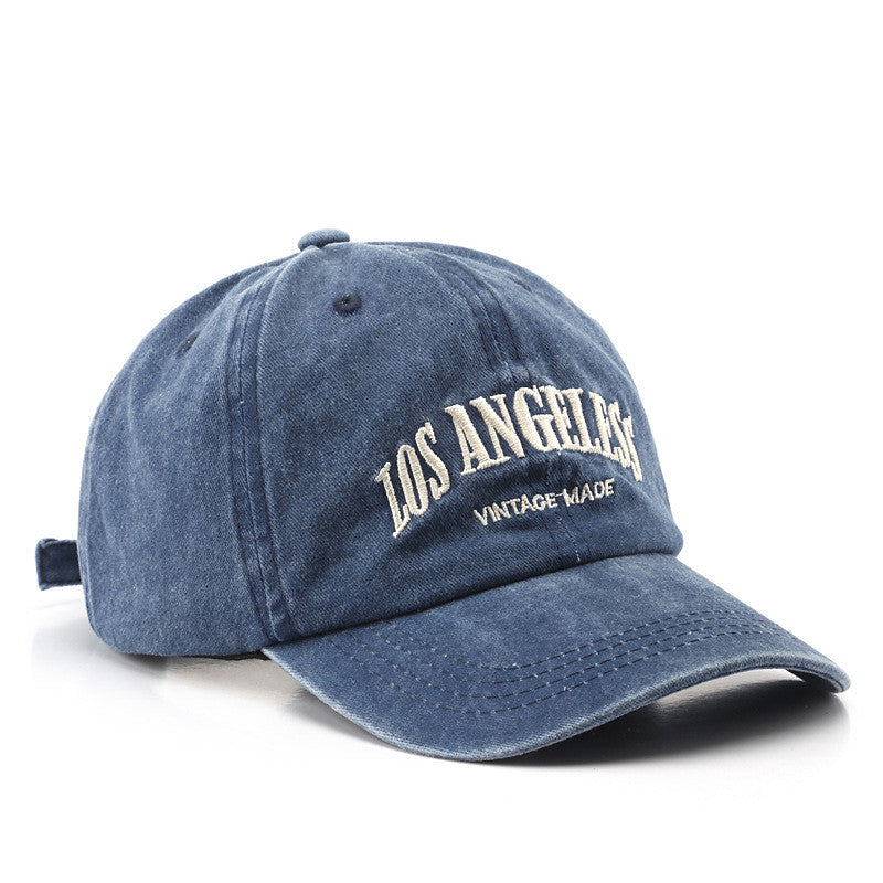 Unisex distressed cotton baseball cap with embroidered lettering in a vintage-inspired aesthetic.