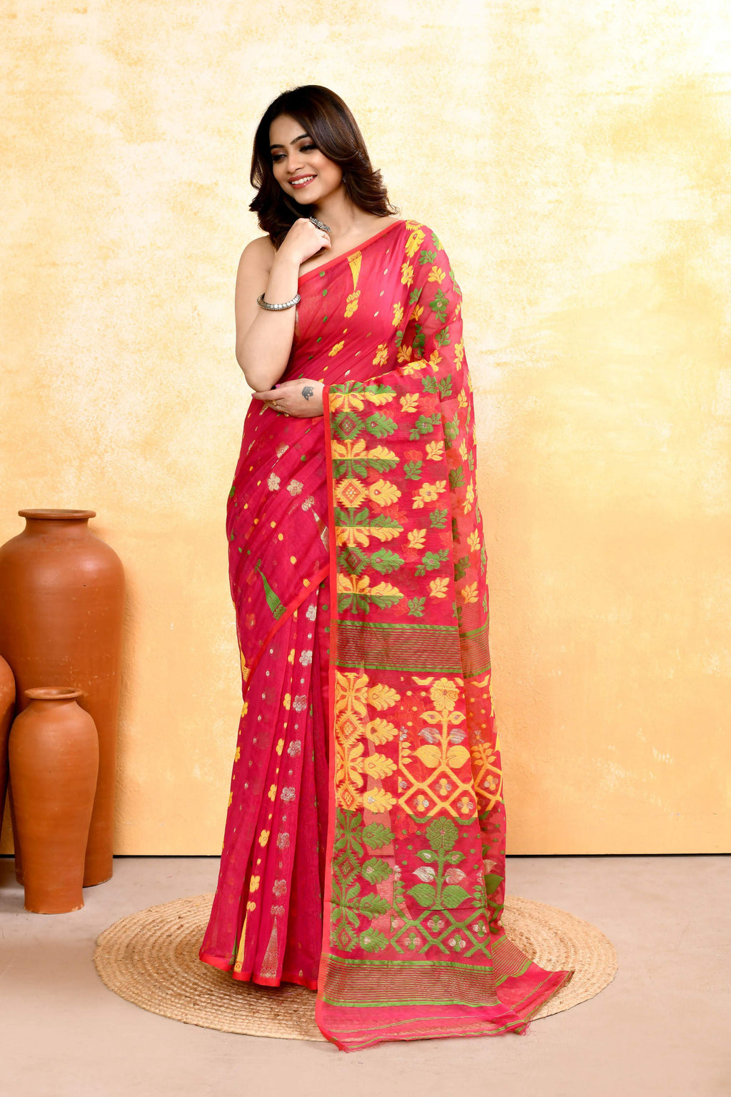 A vibrant red cotton blend Jamdani saree with delicate embellishments displayed elegantly.