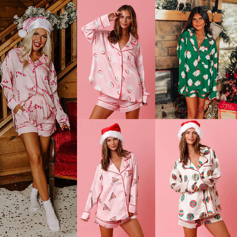 Model wearing a women's pink satin pajama set with a Santa Claus holiday print, including a long-sleeve button-down shirt and matching shorts.