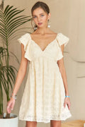 A cream-colored bohemian summer dress with V-neckline and ruffle sleeves