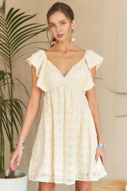 A cream-colored bohemian summer dress with V-neckline and ruffle sleeves