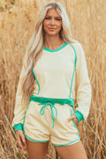 Model wearing a yellow long sleeve pullover and matching drawstring shorts set with green contrast piping