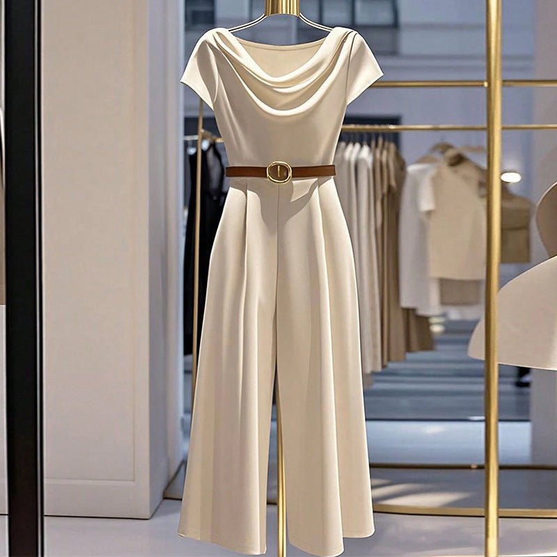 Woman wearing an elegant apricot satin wide-leg jumpsuit with a cowl neckline and formal fitted silhouette.
