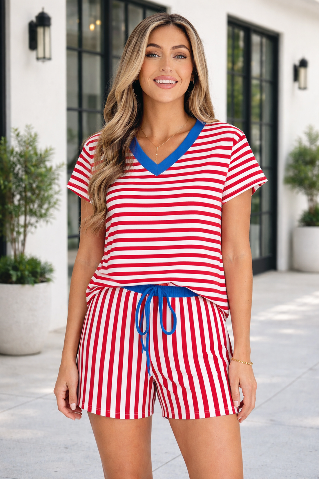 Woman wearing a Skye Stripe Trim Tee Set featuring a red, white, and blue striped V-neck top and matching shorts.