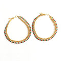 Close up of gold-plated multi kundan anklets with red, green, and white stones