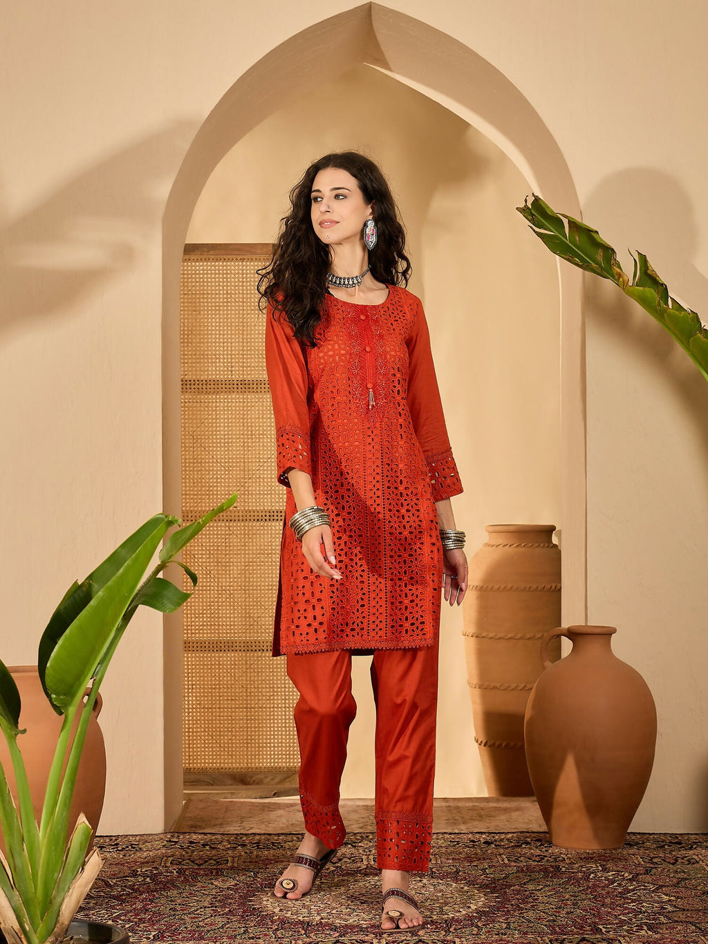 Woman wearing a rust-colored pure cotton embroidered co-ord set with contemporary design.