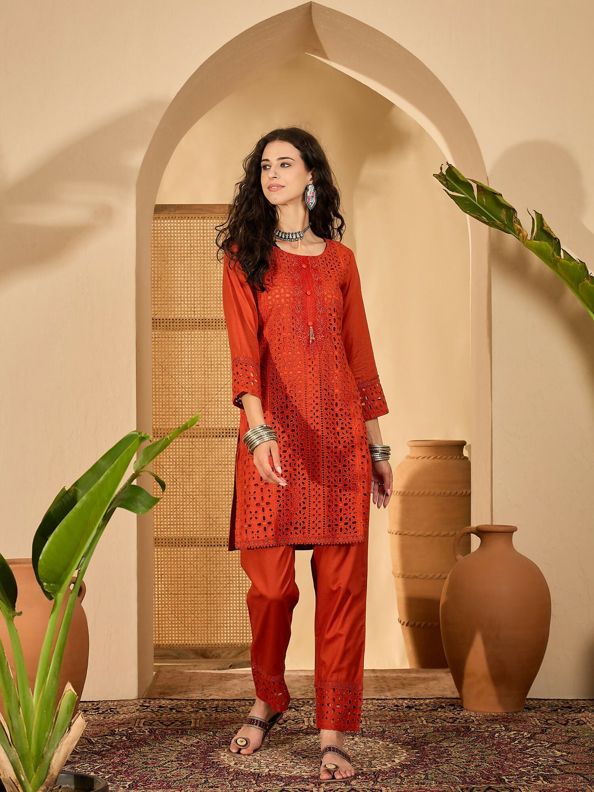 Woman wearing a rust-colored pure cotton embroidered co-ord set with contemporary design.