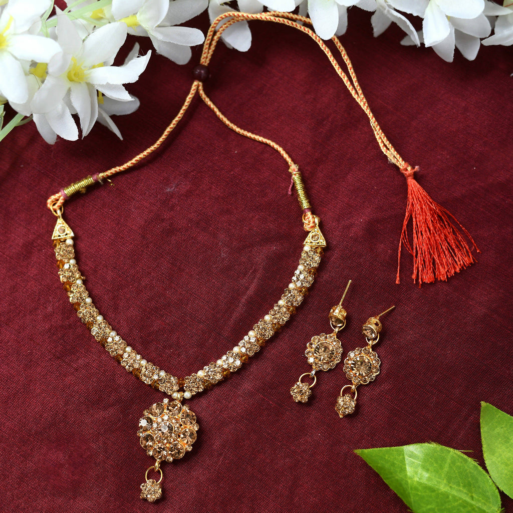Close-up of a gold-polished brass floral Kamal stone choker necklace on a display.