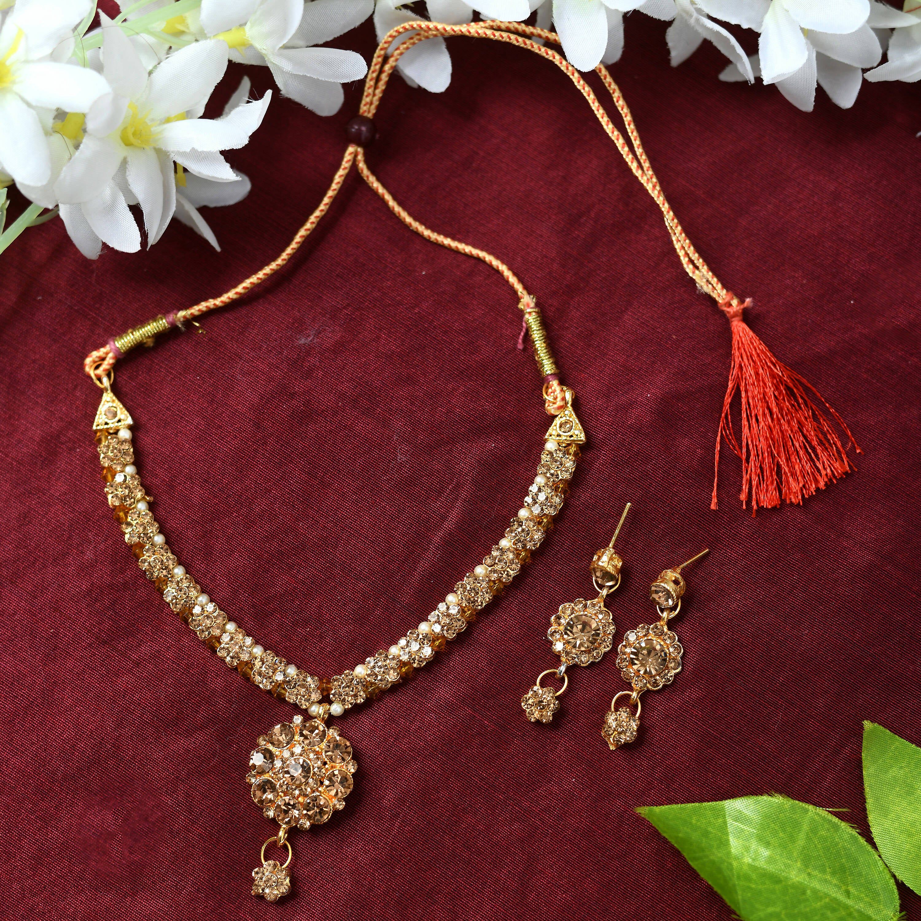 Close-up of a gold-polished brass floral Kamal stone choker necklace on a display.