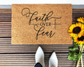 Faith Over Fear text on a natural brown coir doormat with black text