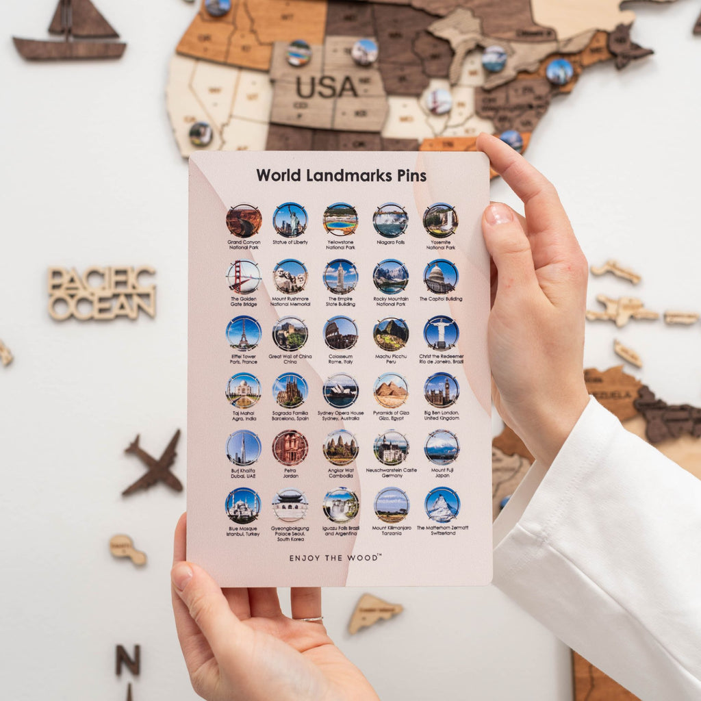 Close-up of wooden world landmark pins on a map board showing famous travel locations.