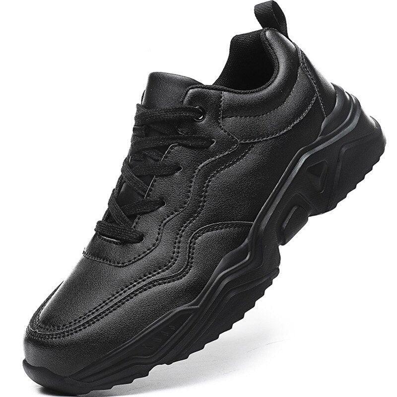 Men's monochromatic black leather winter sneakers with plush lining and lace-up closure in a streetwear setting.