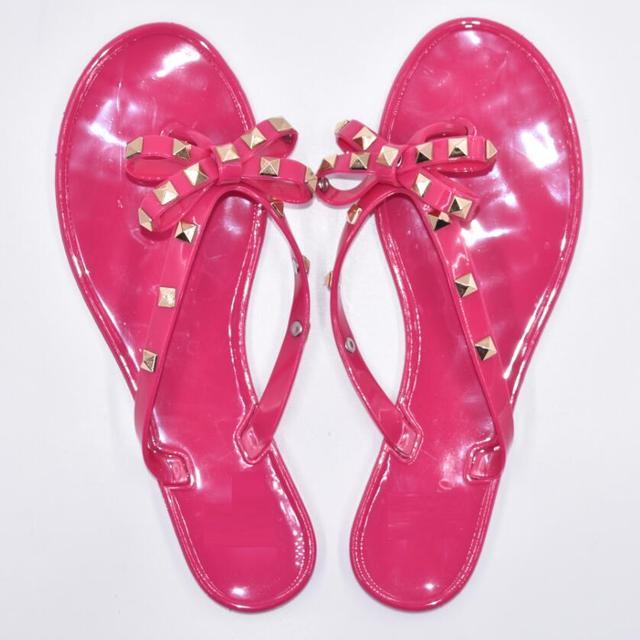 Glamorous women's flat flip flops with a large bowknot detail, available in pink, beige, and black.
