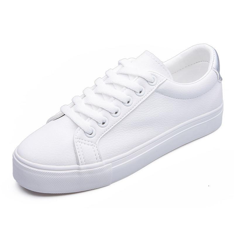 Classic white low-top leather women's sneakers with lace-up closure and rubber outsole