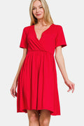 A woman wearing a solid red surplice short sleeve brushed DTY dress with a minimalist aesthetic.