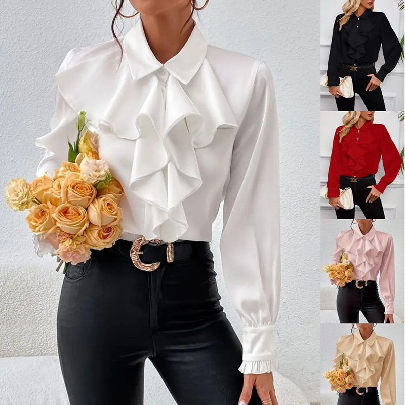 Model wearing a white long-sleeve button-down blouse with large front ruffles and ruffled cuffs.