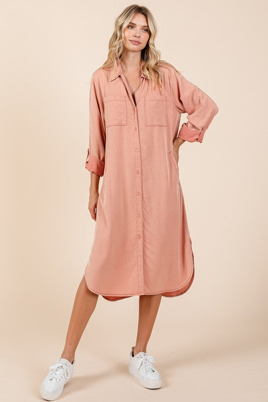 Woman wearing a solid Dusty Rose long sleeve button-down shirt dress in a minimalist setting.