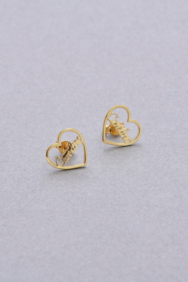 Close up of personalized gold-tone custom script name stud earrings