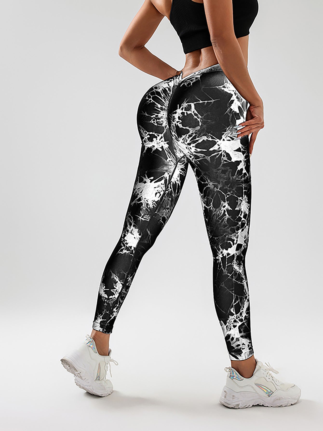 Women wearing black and white tie-dye slimming yoga leggings with butt-lifting design