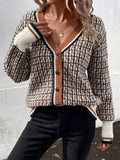 Woman wearing a plaid brown, black, and white V-neck button-up cardigan sweater