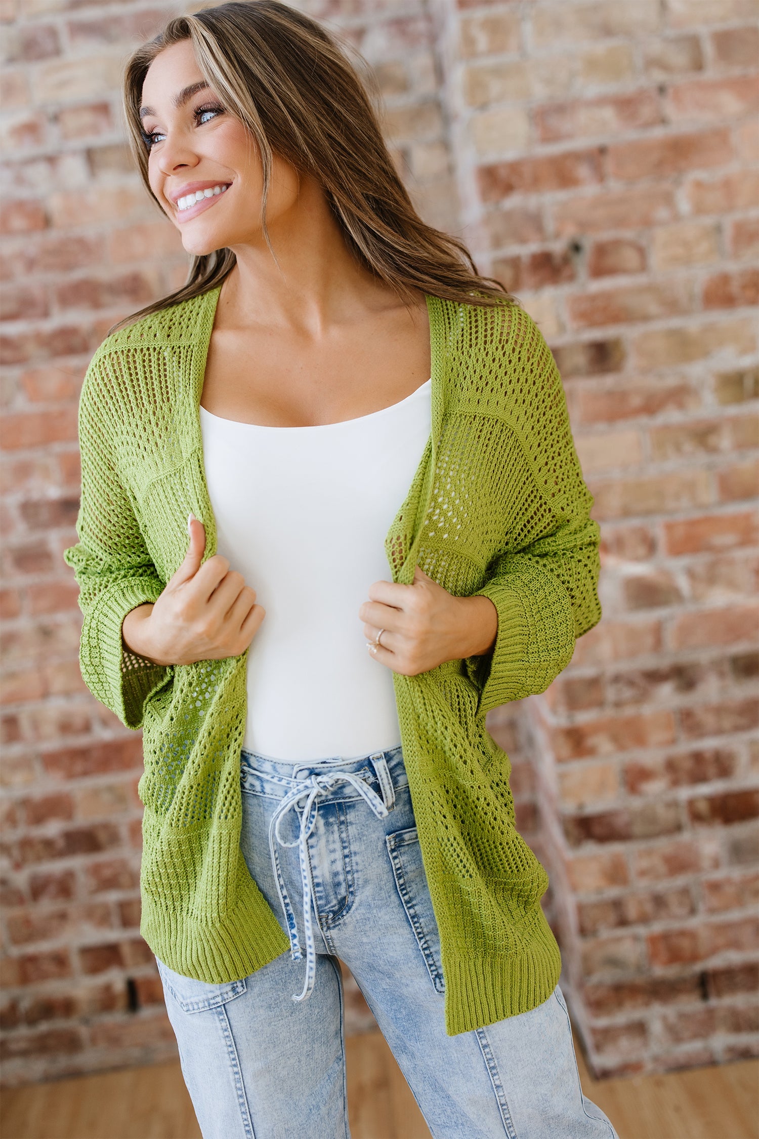 Back and front view of a woman wearing a lime green crochet knit open-front cardigan