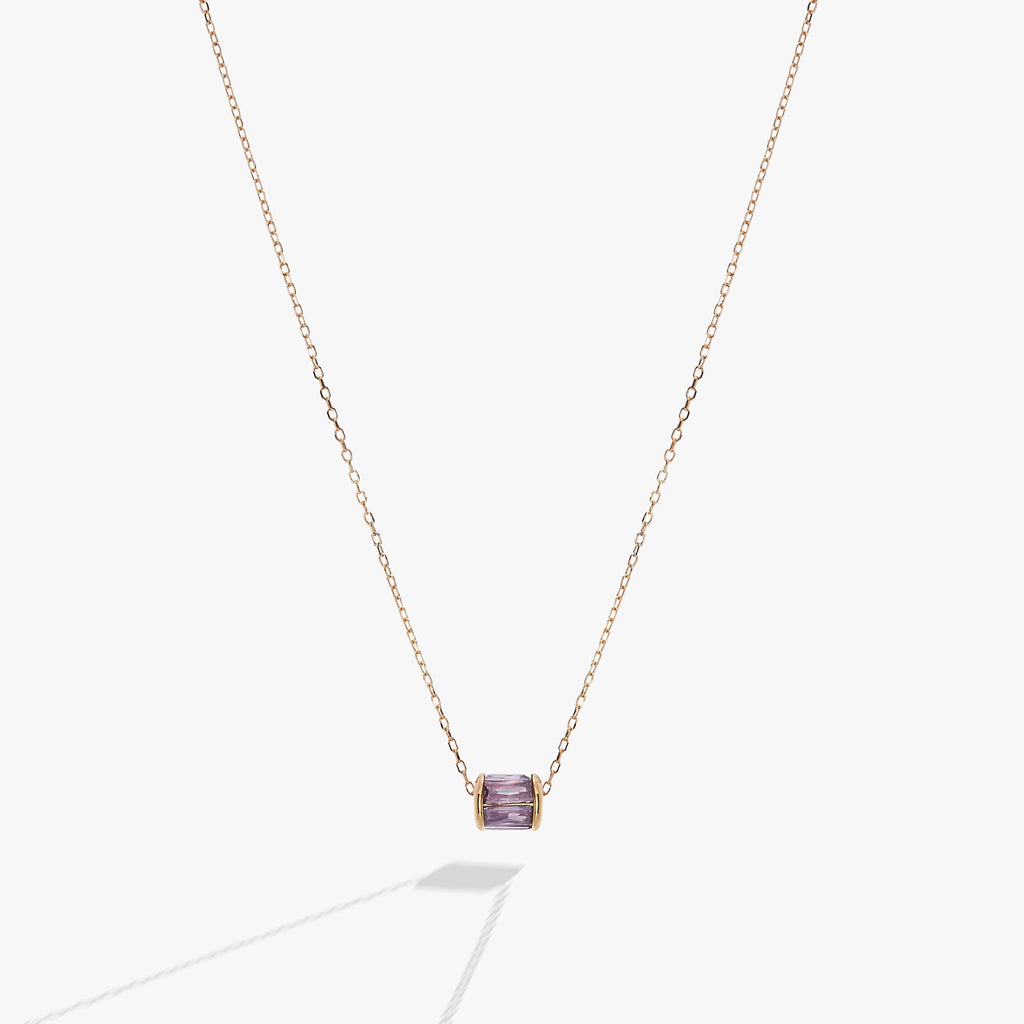 February birthstone necklace featuring a gold-plated barrel pendant with an amethyst-hued crystal on a fine cable chain.
