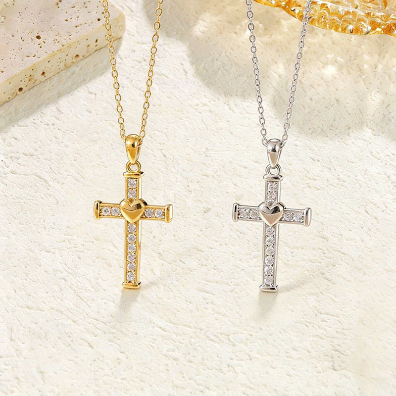 Close-up of a heart-shaped cross pendant necklace with clear crystal rhinestones, available in gold and silver stainless steel.