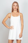 Sleeveless white tennis dress with A-line silhouette and built-in unitard liner for athletic performance.