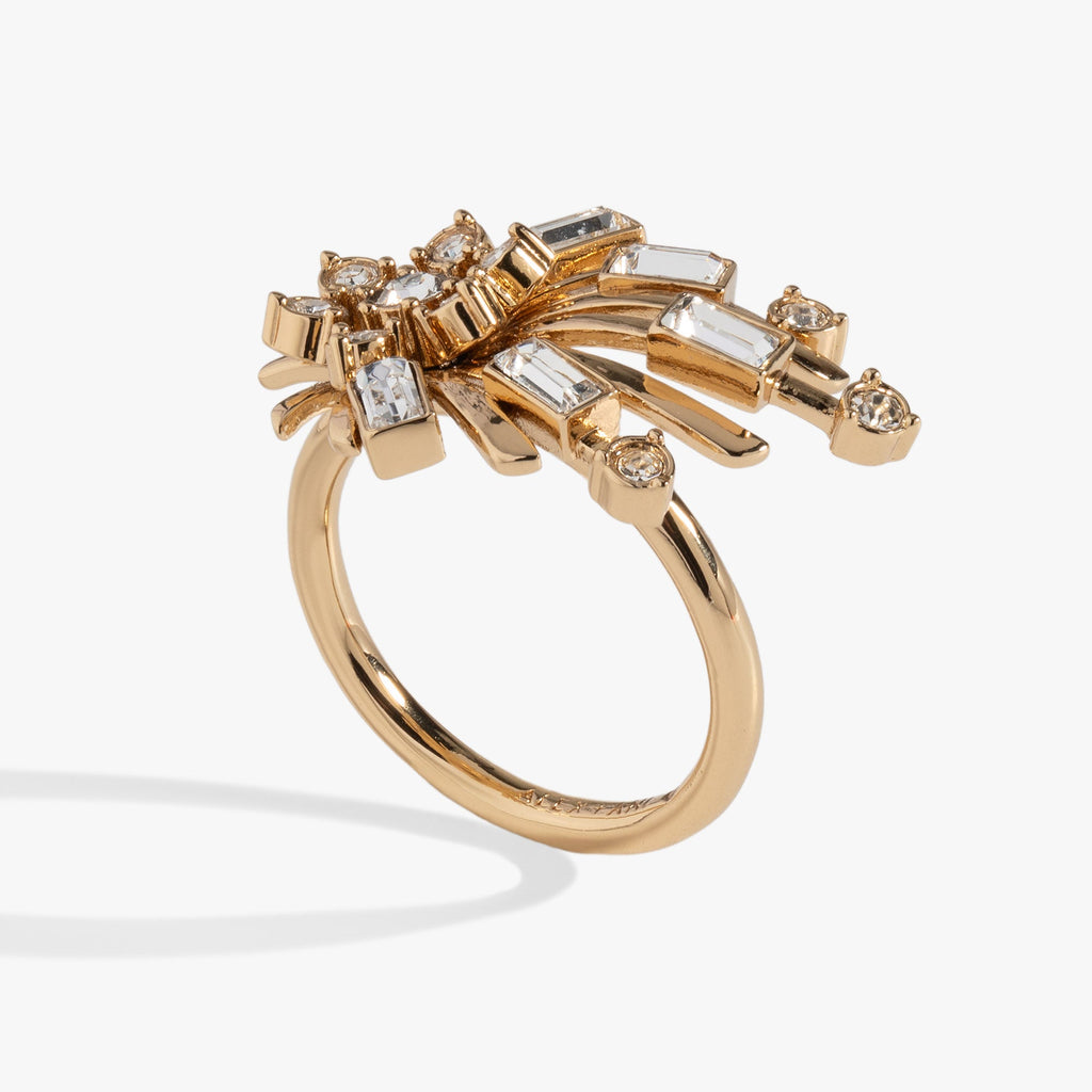 Gold-tone starburst statement ring featuring clear crystal accents on a white background