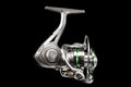 Close-up side and front view of the silver Fission GEN-2 spinning fishing reel with green accents