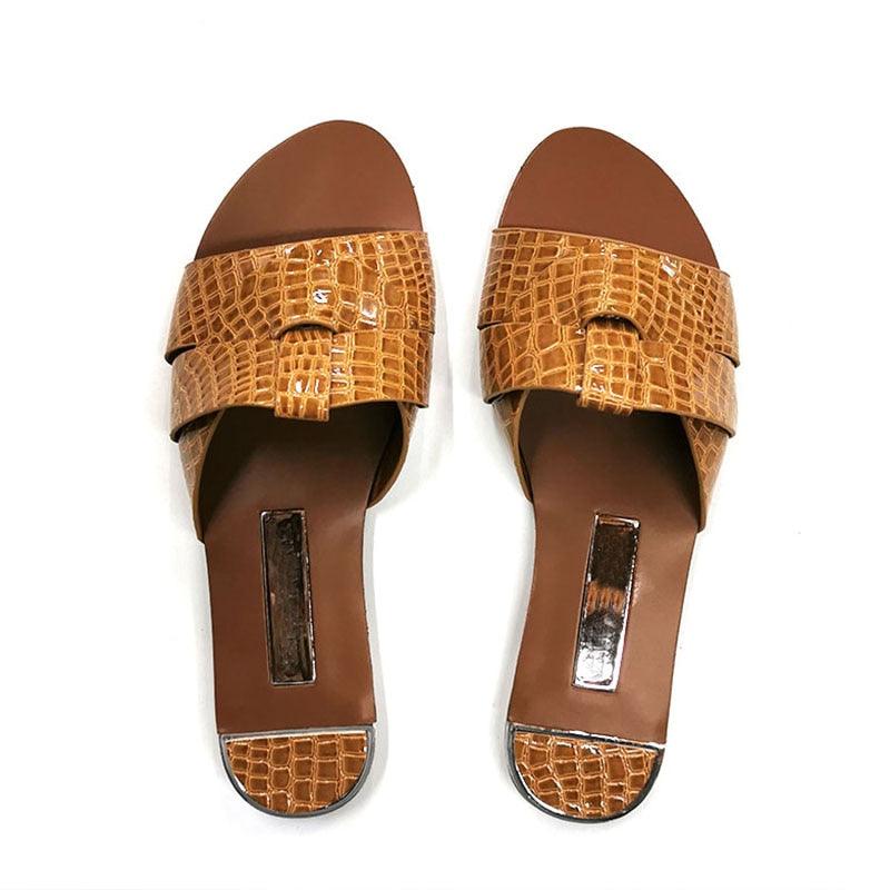 Elegant leather flat sandals in maroon and brown with open-toe design.