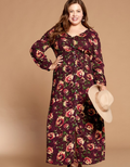 A woman wearing a burgundy and cream floral button-down maxi dress in a bohemian style