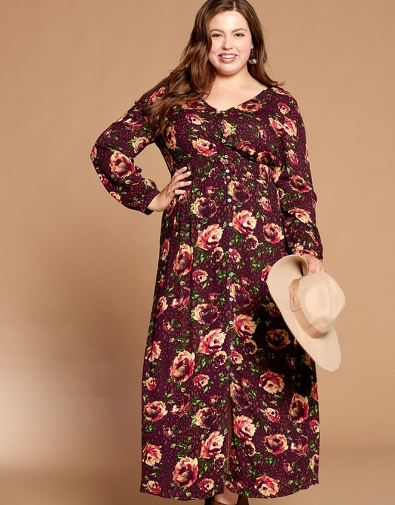 A woman wearing a burgundy and cream floral button-down maxi dress in a bohemian style