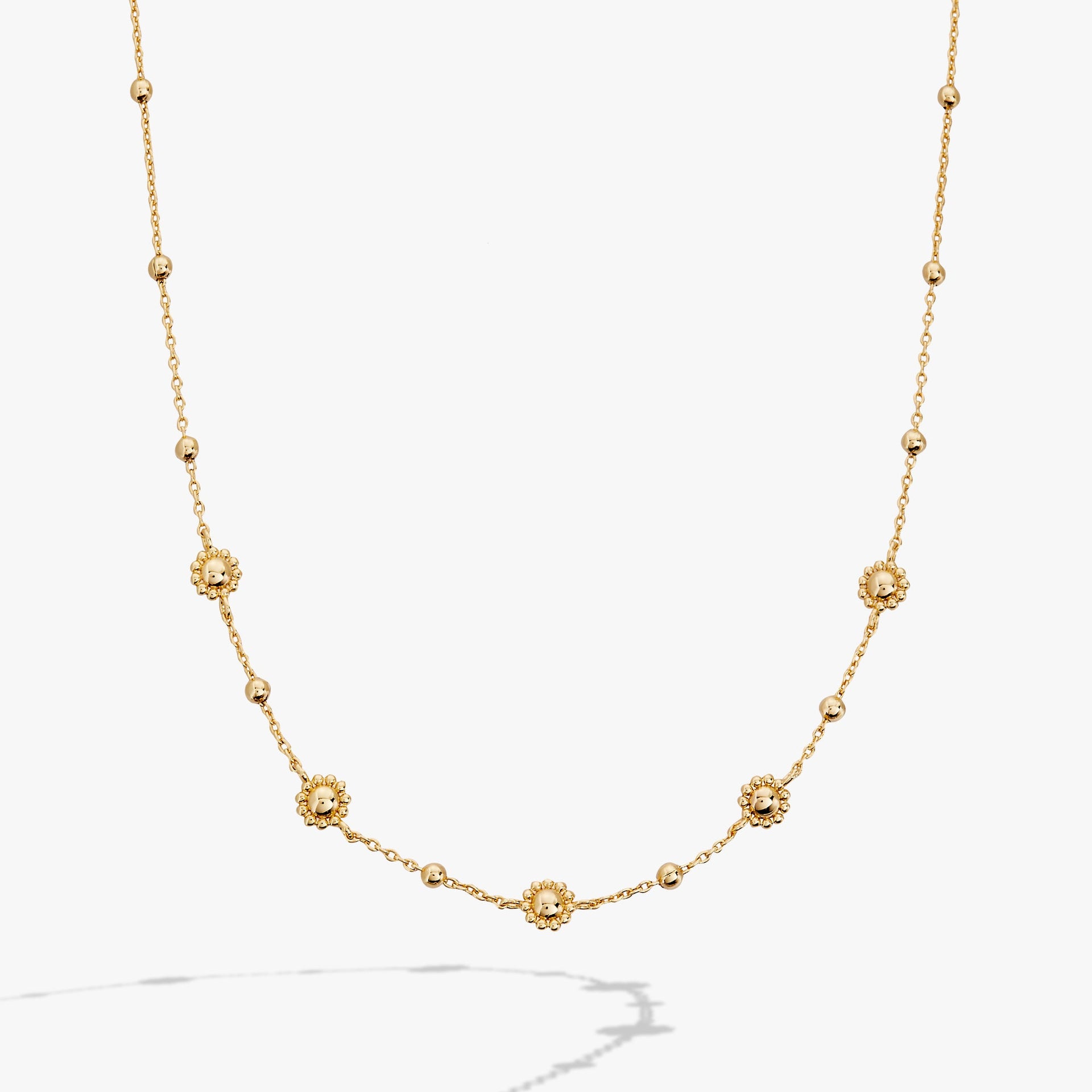 Gold-plated station chain necklace with textured floret charms