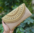 Golden embellished potli clutch for women featuring intricate detailing and synthetic fabric