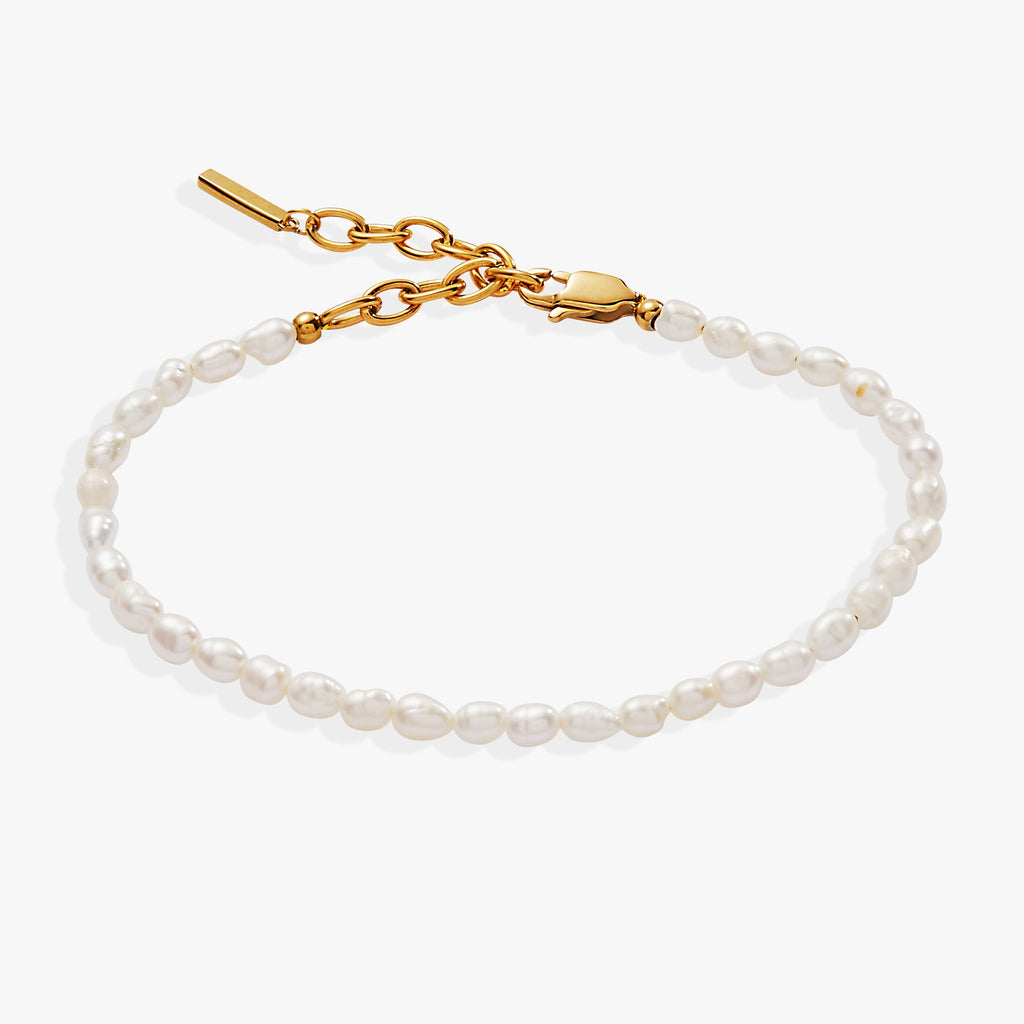 Adjustable freshwater pearl bracelet with gold-tone accents on a neutral background.