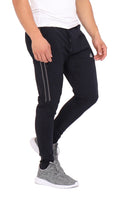A man wearing black performance joggers with side stripe detail and zippered leg openings.