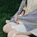 Elegant Frosted Forest Wrap knitting pattern displayed in shades of grey, purple, and blue.