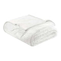 A white reversible velvet plush and sherpa fleece blanket folded neatly