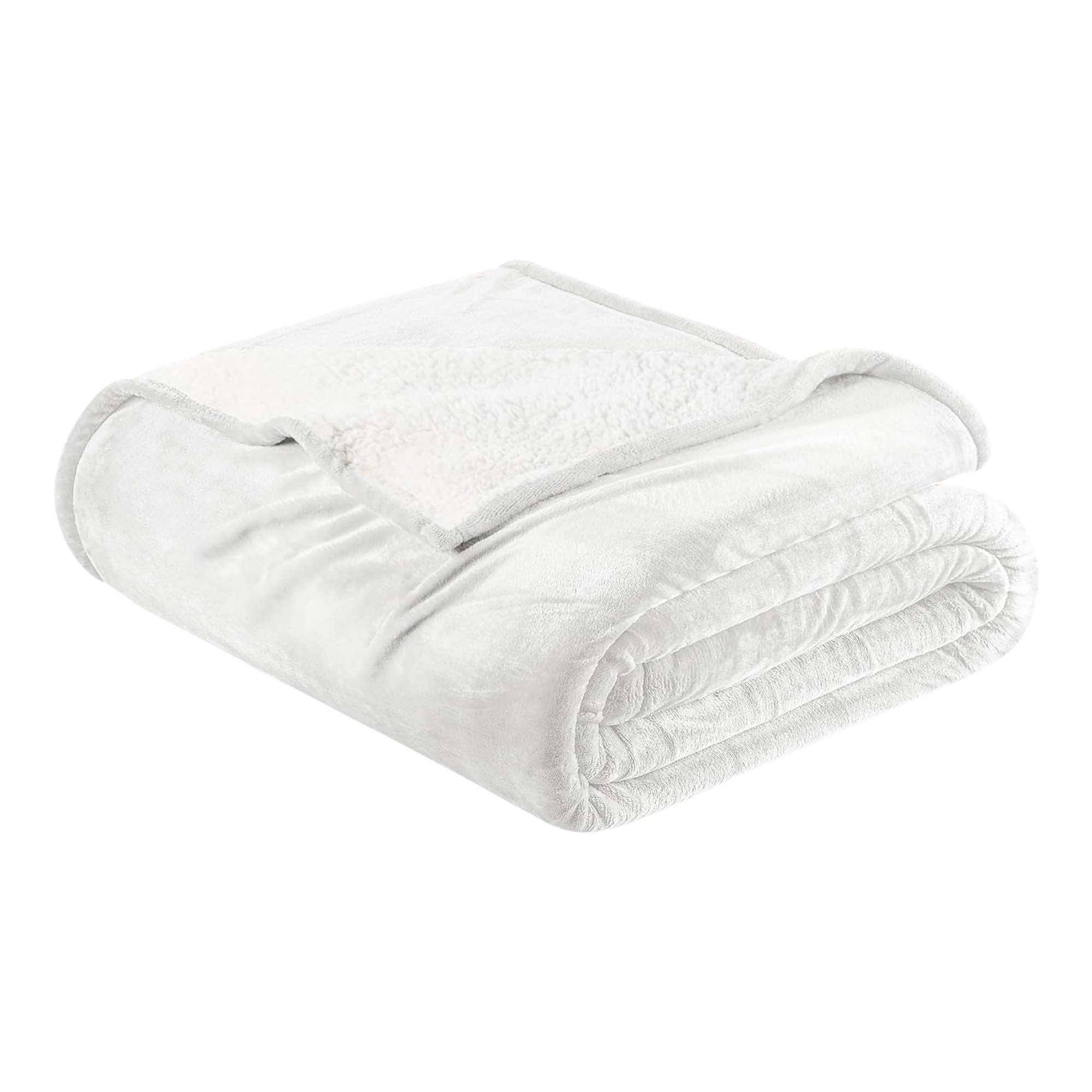 A white reversible velvet plush and sherpa fleece blanket folded neatly