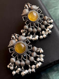 Mustard yellow Monalisa stone stud earrings set in antique black polished brass.