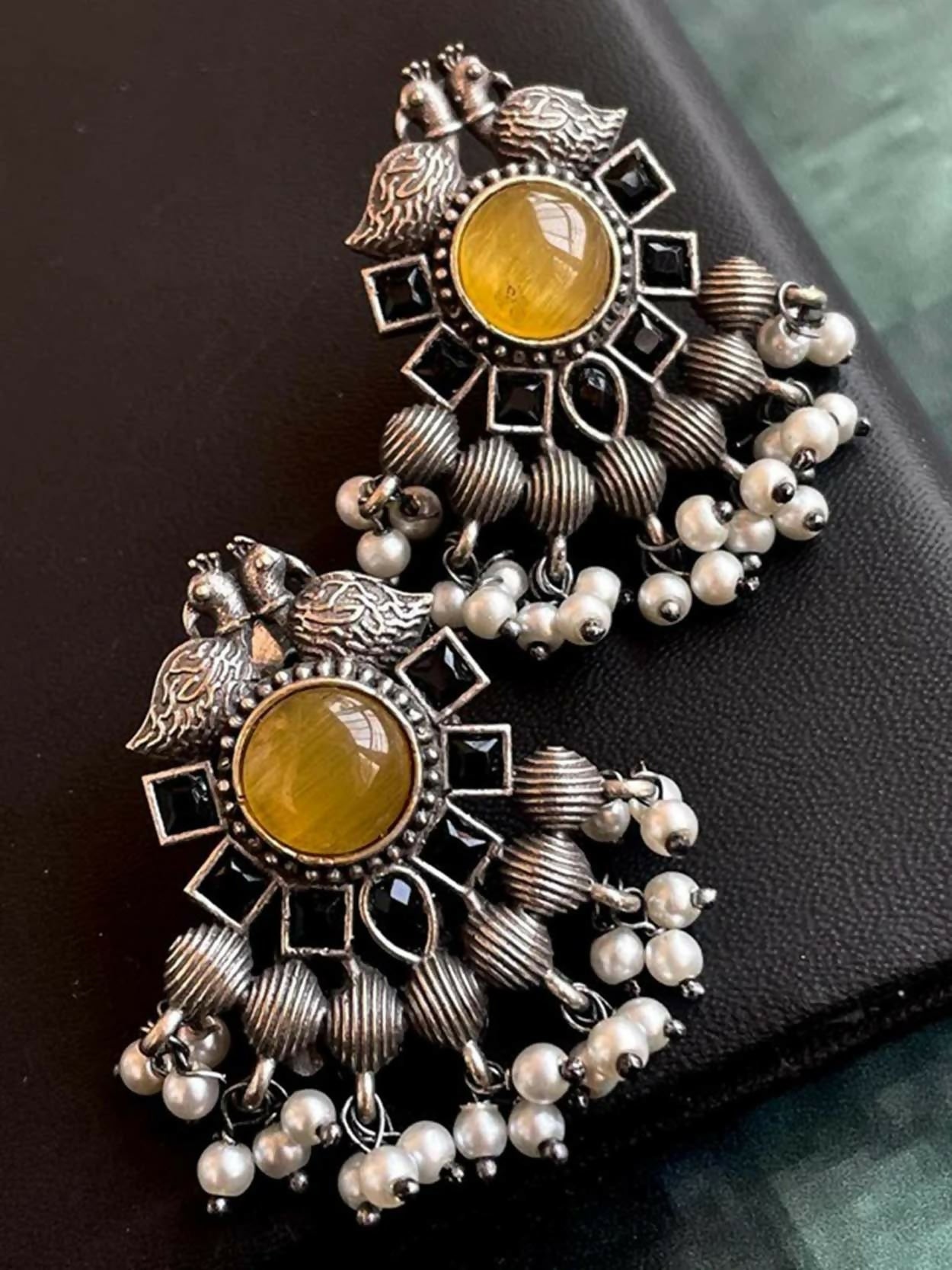 Mustard yellow Monalisa stone stud earrings set in antique black polished brass.