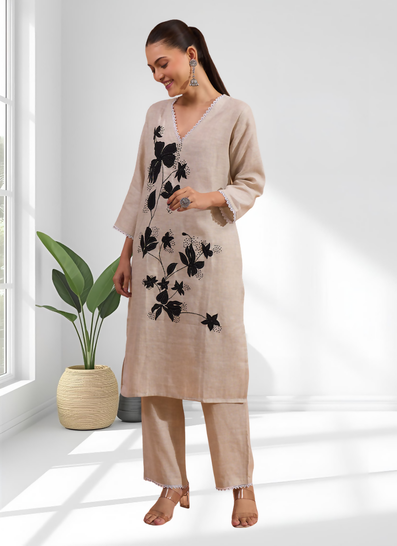 Close up of beige linen fabric on a long kurta with detailed embroidery and matching pant.